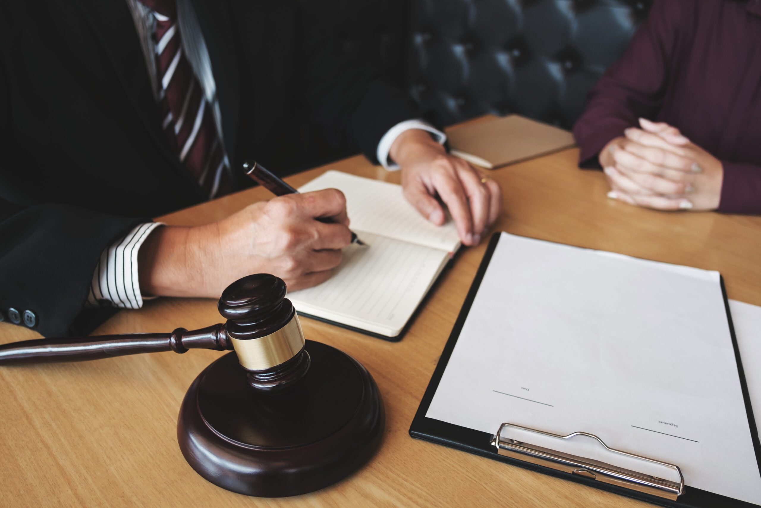 Two people writing on a judges desk